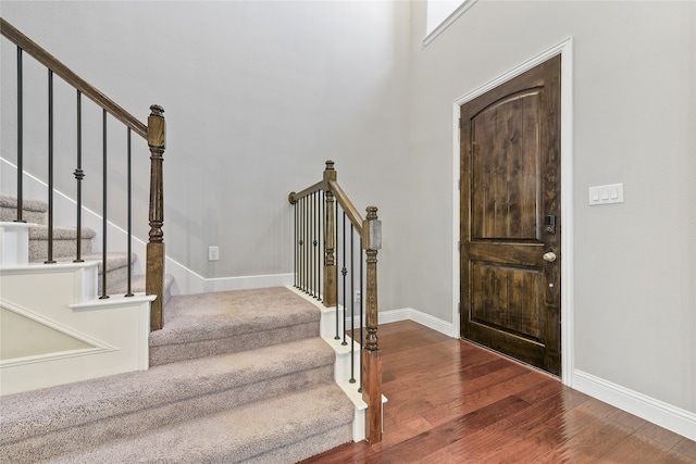 foyer featuring stairs, baseboards, and wood finished floors