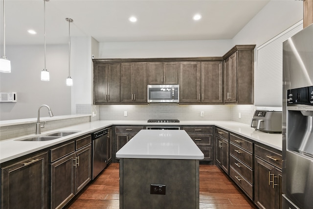 kitchen with a sink, dark brown cabinets, stainless steel appliances, and dark wood-type flooring