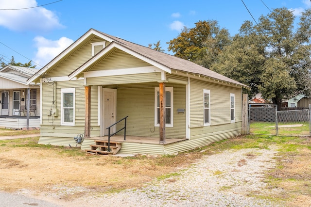 view of front of property with covered porch, fence, and a gate