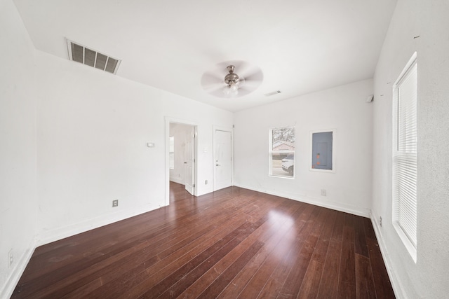 spare room with ceiling fan, dark wood-type flooring, visible vents, baseboards, and electric panel