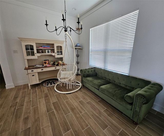 living area featuring wood tiled floor, crown molding, a chandelier, and built in desk