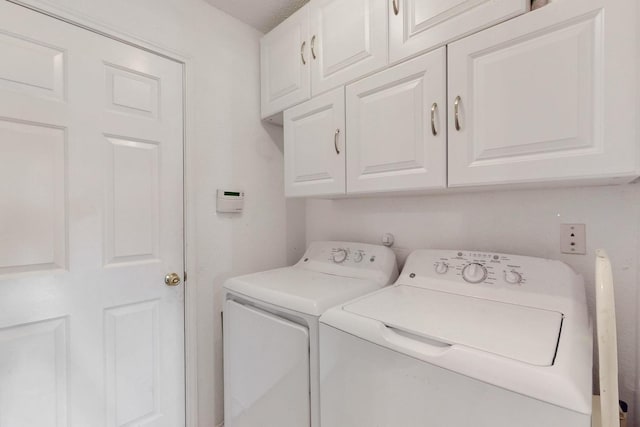 laundry area featuring independent washer and dryer and cabinet space