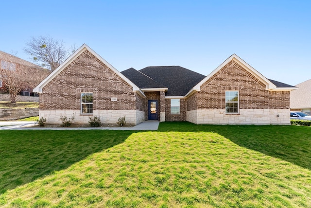 single story home with a shingled roof, a front lawn, and brick siding