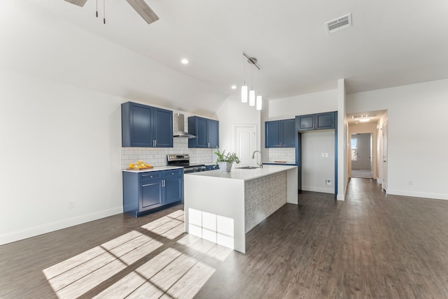 kitchen featuring electric stove, blue cabinetry, light countertops, a sink, and wall chimney exhaust hood