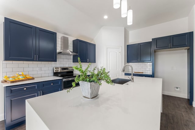 kitchen featuring stainless steel electric range oven, blue cabinets, a kitchen island with sink, wall chimney range hood, and a sink