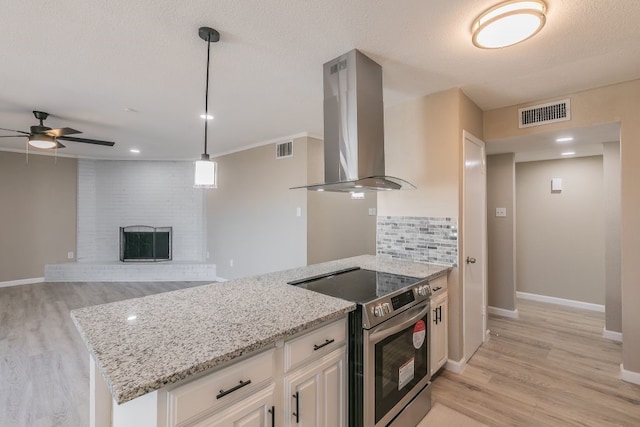 kitchen featuring light stone countertops, visible vents, electric range, and exhaust hood