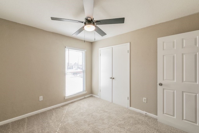 unfurnished bedroom featuring ceiling fan, carpet floors, a closet, and baseboards