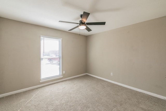 spare room with carpet floors, baseboards, and a ceiling fan