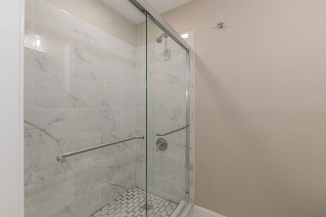 bathroom with a marble finish shower