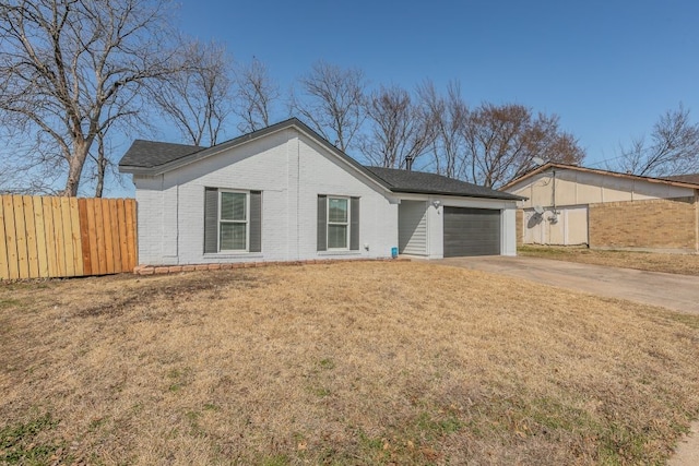 view of front facade featuring brick siding, concrete driveway, an attached garage, fence, and a front lawn