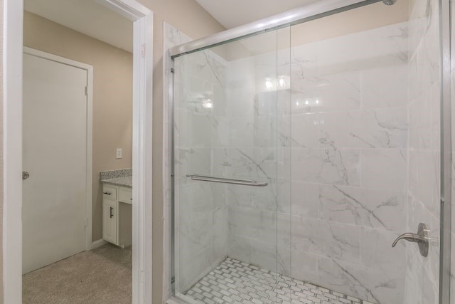 bathroom featuring a marble finish shower and vanity