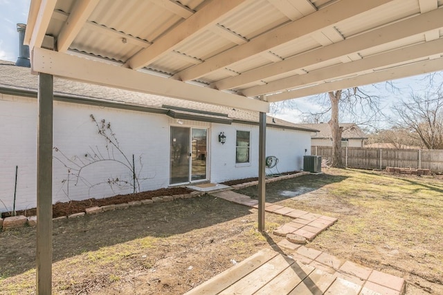 exterior space with brick siding, cooling unit, and fence