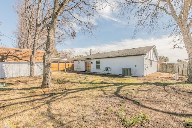 rear view of house featuring a fenced backyard, cooling unit, and a yard