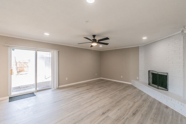 unfurnished living room with light wood finished floors, baseboards, a fireplace, and ornamental molding