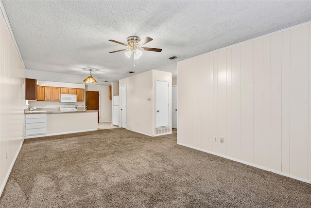 unfurnished living room featuring ceiling fan, a textured ceiling, visible vents, and light colored carpet