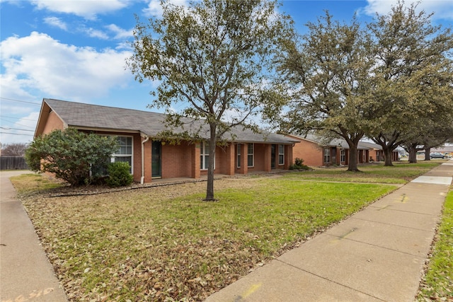 single story home with a front yard and brick siding