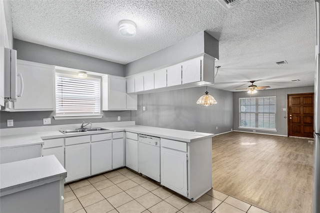 kitchen with open floor plan, white cabinetry, a sink, white appliances, and a peninsula