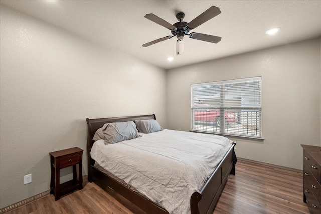 bedroom featuring wood finished floors, a ceiling fan, and recessed lighting