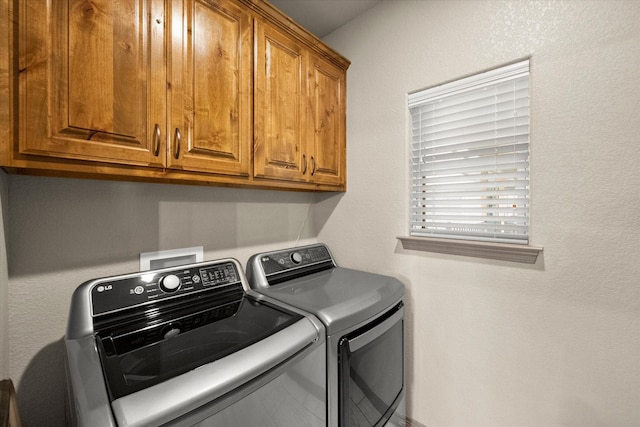 clothes washing area featuring cabinet space and washing machine and clothes dryer