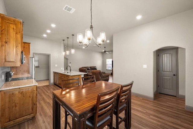 dining space featuring arched walkways, recessed lighting, visible vents, wood finished floors, and baseboards