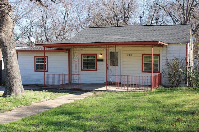 bungalow with a porch, a front yard, and roof with shingles