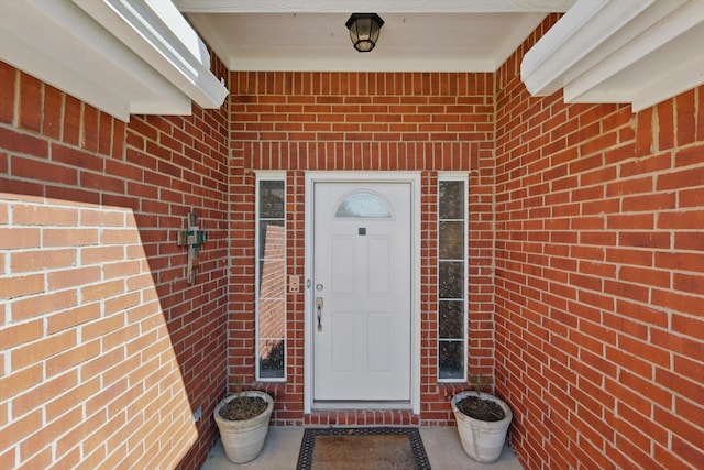 entrance to property featuring brick siding