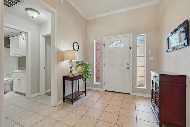 entrance foyer with light tile patterned flooring, visible vents, baseboards, plenty of natural light, and crown molding