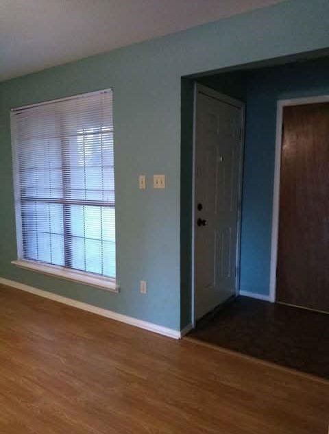 empty room with baseboards and wood finished floors