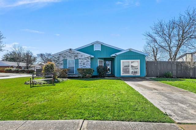 view of front of home with driveway, a front yard, and fence