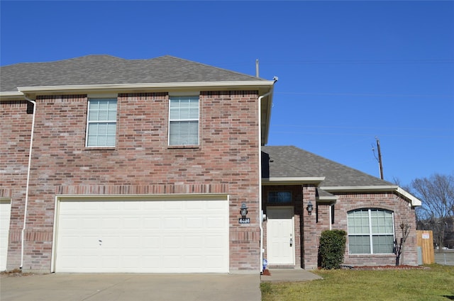 view of front facade featuring concrete driveway, a shingled roof, and brick siding