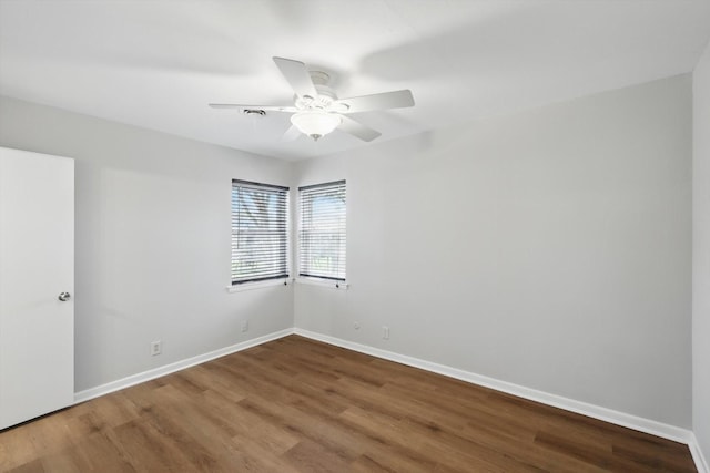 spare room with a ceiling fan, baseboards, and wood finished floors