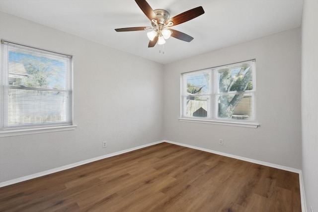 spare room featuring a ceiling fan, baseboards, and wood finished floors