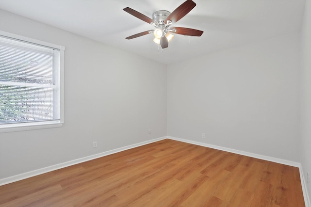 empty room with ceiling fan, light wood-style flooring, and baseboards