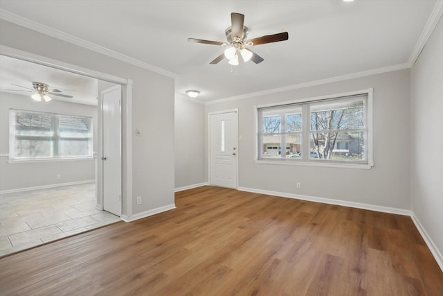 spare room with a healthy amount of sunlight, crown molding, and wood finished floors