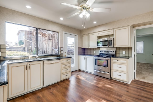 kitchen with stainless steel appliances, dark countertops, and dark wood-type flooring