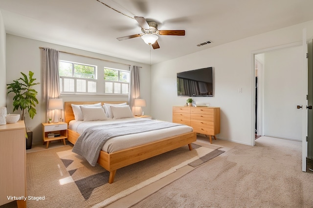 bedroom featuring ceiling fan, baseboards, visible vents, and light colored carpet