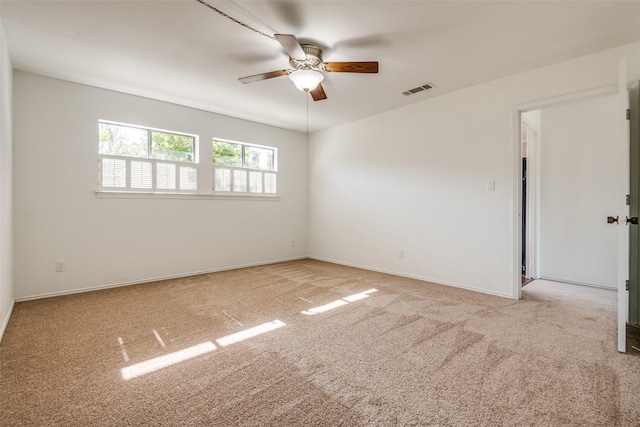 empty room featuring ceiling fan, carpet, visible vents, and baseboards