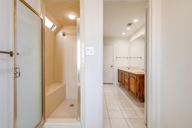 full bathroom featuring double vanity, visible vents, a stall shower, a sink, and tile patterned floors