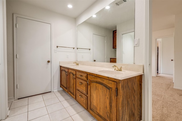 bathroom with double vanity, tile patterned flooring, visible vents, and a sink