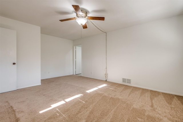 carpeted empty room with ceiling fan and visible vents