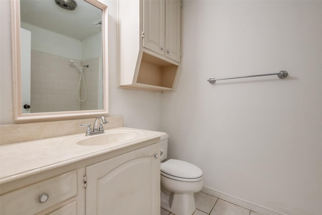 bathroom with tile patterned flooring, toilet, vanity, baseboards, and a shower