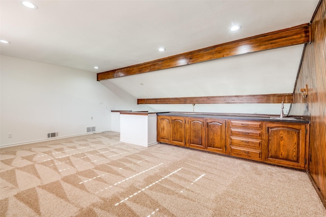 kitchen featuring brown cabinets, light colored carpet, and visible vents