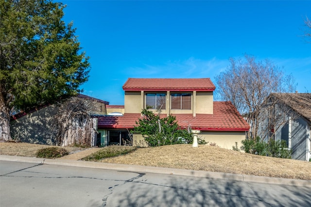 view of front of house featuring a tiled roof and stucco siding