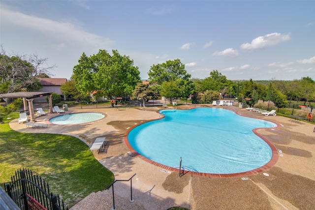 pool with fence, a lawn, and a patio