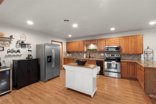 kitchen with tasteful backsplash, visible vents, light wood-style flooring, stainless steel appliances, and open shelves