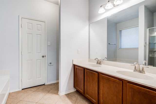 full bathroom featuring a garden tub, double vanity, a sink, and tile patterned floors