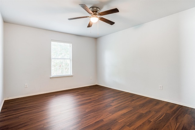 empty room with baseboards, a ceiling fan, and dark wood-style flooring