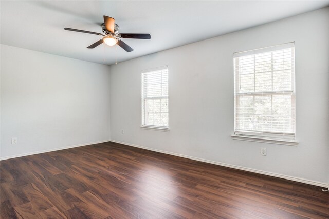 empty room featuring a ceiling fan, dark wood finished floors, and baseboards