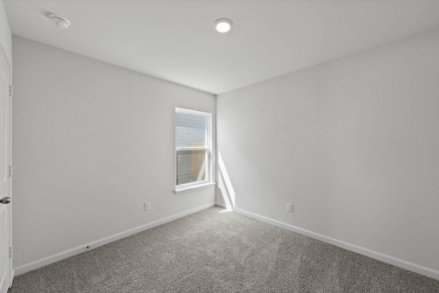 carpeted spare room with baseboards