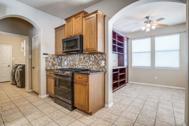 kitchen featuring light tile patterned floors, ceiling fan, stainless steel appliances, independent washer and dryer, and tasteful backsplash